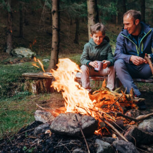 ojciec i syn przy ognisku podczas obozu survivalowego